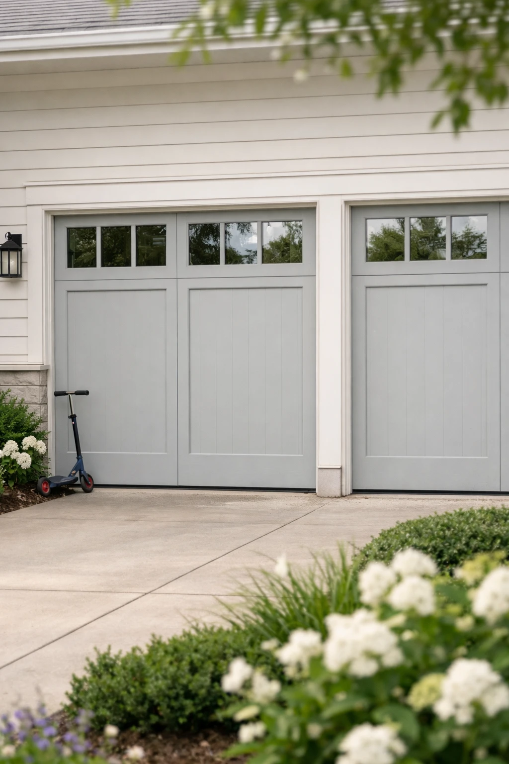 A suburban home with garage doors featuring top-row windows and balanced exterior styling.